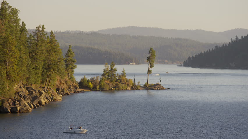 Wide shot of hot air balloon and boats at lake / Coeur d