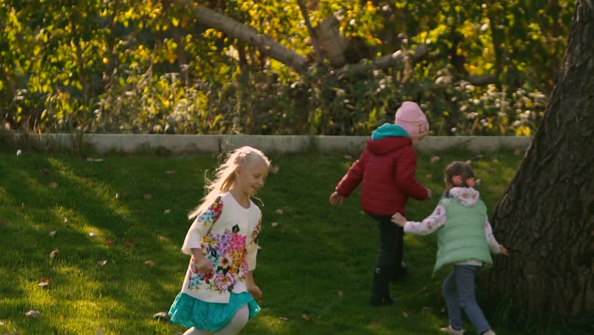 Little blond girl playing with other children on field