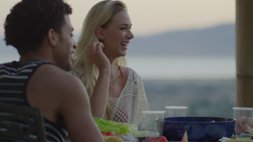 Medium panning shot of friends laughing at barbecue / Cedar Hills, Utah, United States