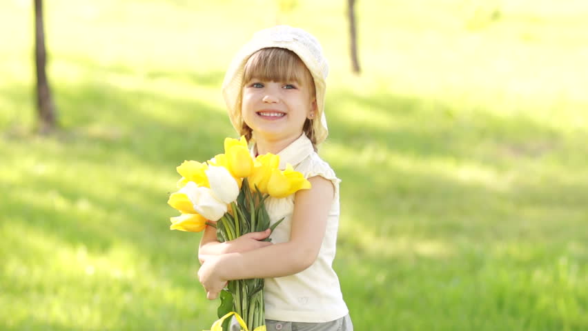 Girl is spinning with a bouquet of yellow tulips