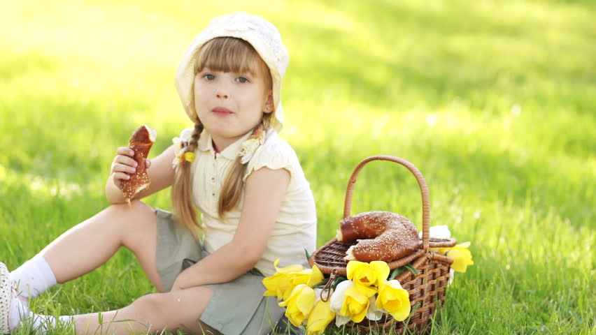Girl eat bread and sitting in the meadow. Sequence