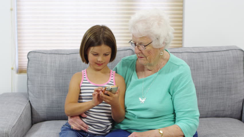 grandma helping granddaughter use cellphone: стоковое видео (без лицензионн...