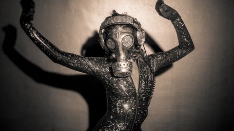 Sexy woman dances with a gas mask covered in sparkling crystals. how to survive the apocalypse in bling bling style.