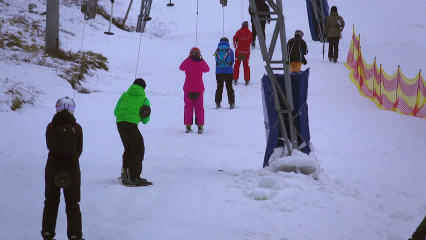 Skiers ascend the mountain on a ski lift