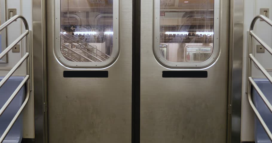 An interior view of the doors on a New York City subway car as they open at an empty platform.  No passengers, perhaps during a pandemic like COVID-19 or Coronavirus.	 Royalty-Free Stock Footage #22512283