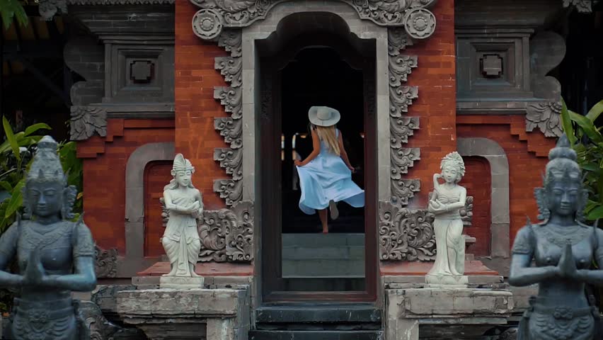Back view of a stylish female tourist admires of a beautiful architectural building during walking in foreign city