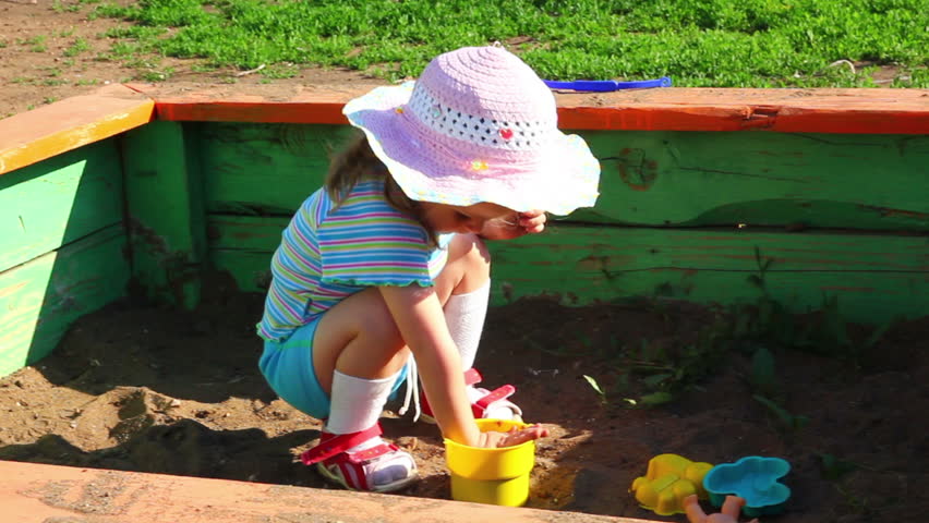 little girl playing in sandbox