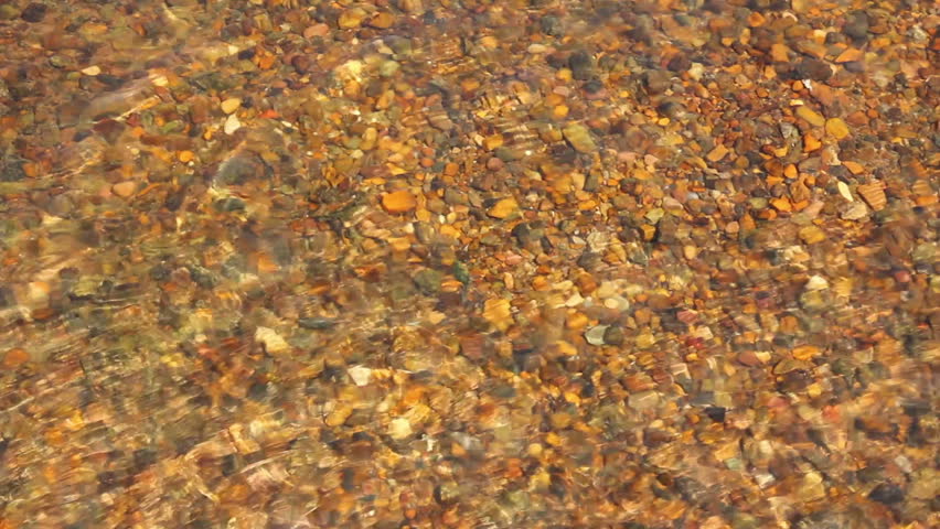 transparent river water in shallow with pebbles