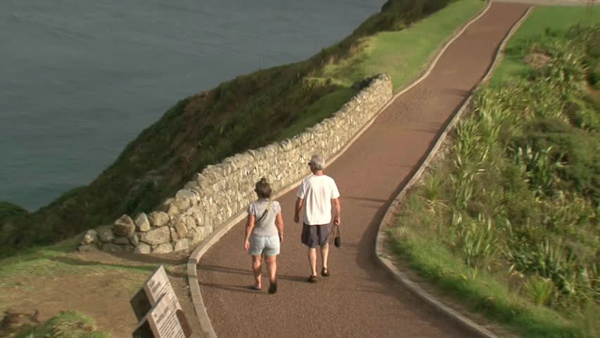 tourists walking towards Cape Reinga lighthouse, New Zealand