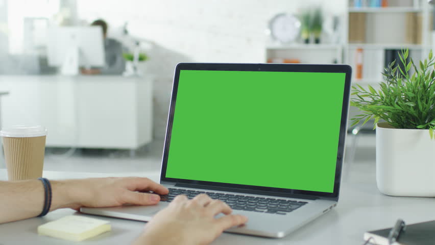 Close-up of a Man's Hands Working on Green Screen on a Laptop. In Background Blurred and Brightly Lit Office where One Man Approaches the Other and They Have Discussion. Shot on RED EPIC (uhd). Royalty-Free Stock Footage #22521139