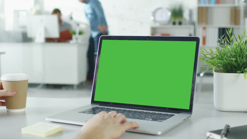 Close-up of a Man's Hands Working on Green Screen on a Laptop. In Background Blurred and Brightly Lit Office where One Man Approaches the Other and They Have Discussion. Shot on RED EPIC (uhd).