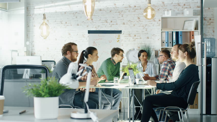 Seven Stylish People Having Planning Session Sitting at Big Table in their Creative Office. Shot on RED EPIC (uhd). | Shutterstock HD Video #22522180