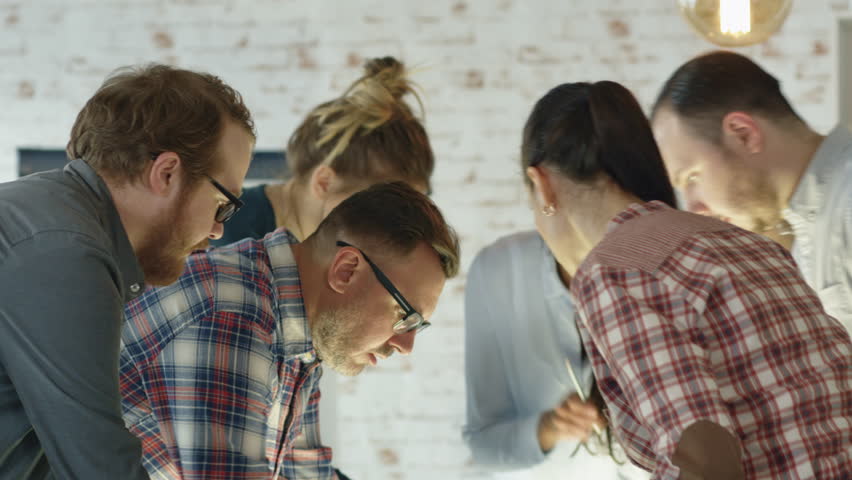 Seven Stylish Diverse People Lean on a Conference Table While Energetically Discussing Daily Business Plans. Shot on RED EPIC 4K(uhd).