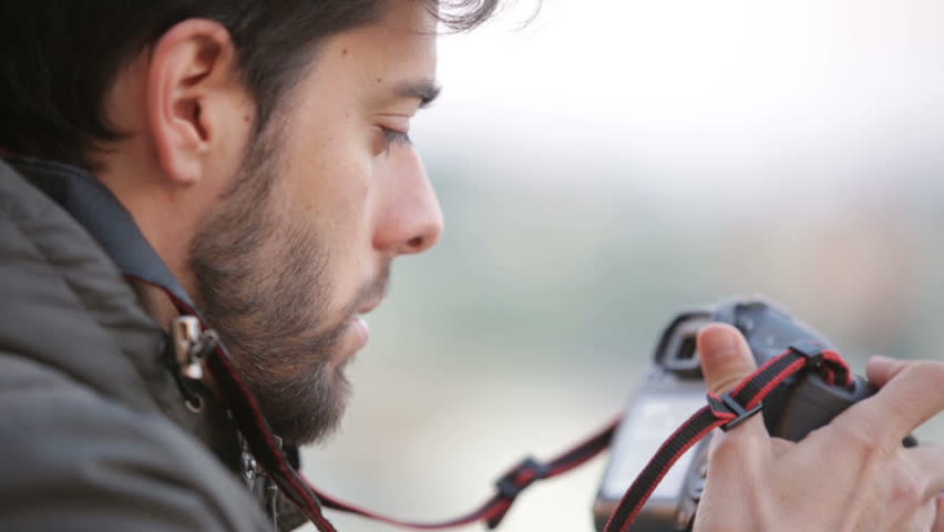 Boy photographer is taking some still with his dslr camera and fish eye lens.