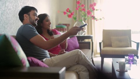 MS Mid-adult couple watching TV in living room / India