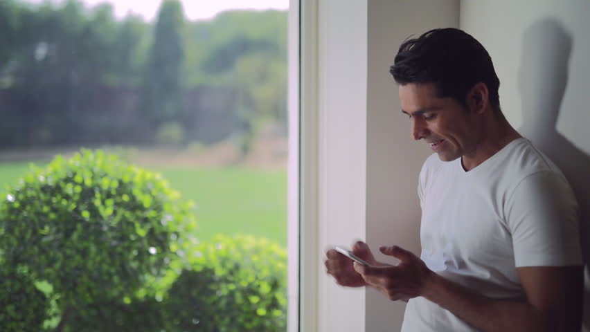 MS Mid-adult man texting and laughing / India
