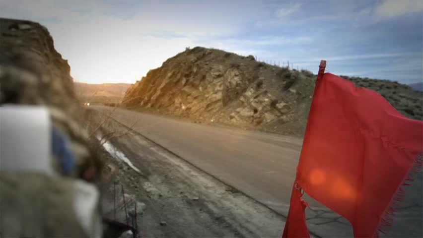 Gauchito Gil Roadside Shrine With Red Flag Waving on Mountain Road, Mendoza, Argentina