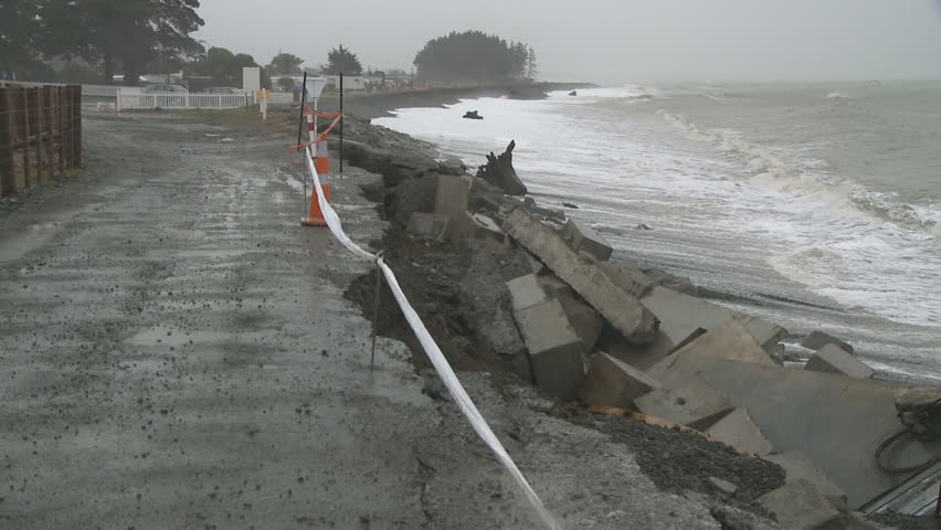 A coastal road sustains sea damage from large storm driven waves