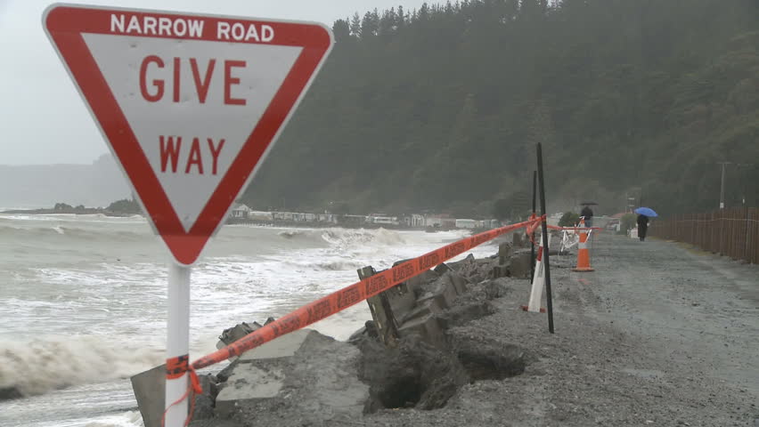 Storm waves damage a coastal road