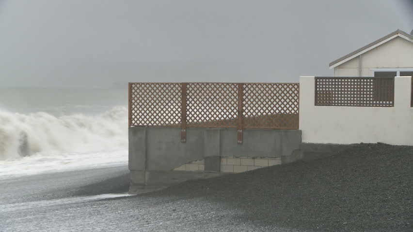 waves pound a coastal property
