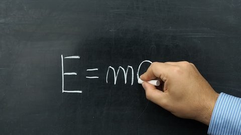 Famous Albert Einstein s equation E=mc2 handwritten on chalkboard or blackboard by teacher or businessman