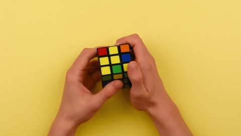 RYBNIK, POLAND -DECEMBER 24, 2016: Teenager's hands solving Rubik's cube puzzle. 