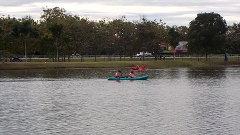 People playing red and blue canoe at lake