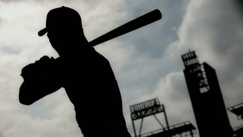silhouetted baseball player taking practice swings