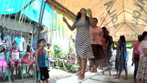 KINABUHAYAN, DOLORES, QUEZON, PHILIPPINES - DECEMBER 25, 2016:  Rural folks Wedding Guests perform bench dance to raise money for newly wed couple 
