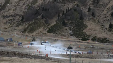Snowmaking gun and chairlifts in the mountains. Puy de Sancy, France.