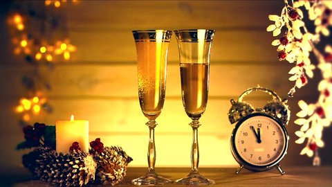 New Year and Christmas Celebration with Champagne.  Two glasses of champagne, candle and old clock.  Full HD 1080 video footage. Slow motion 240 fps.