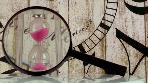 Hourglass and wooden clock and magnify glass