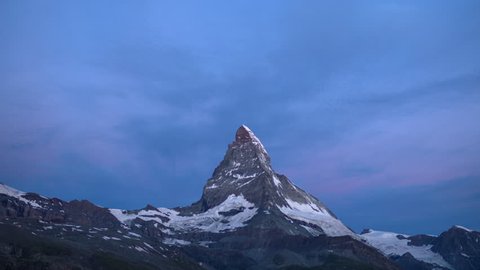 dawn, sunrise time lapse of the amazing matterhorn mountain in the Swiss Alps. the sky lights up in an incredible display of colour followed by the shadow lowering over the mountain