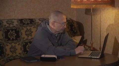old man using laptop computer at home