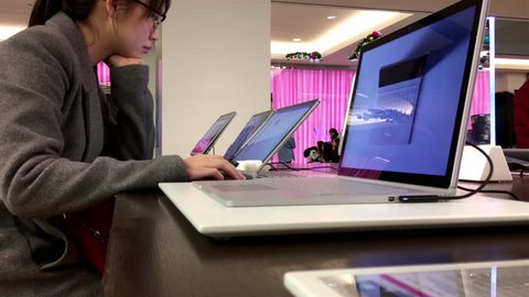 Burnaby, BC, Canada - December 23, 2016 : People playing new computer at Microsoft store in Burnaby BC Canada with 4k resolution