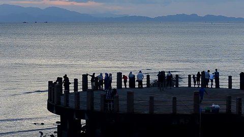 People watching sunset at sea bridge Malaysia