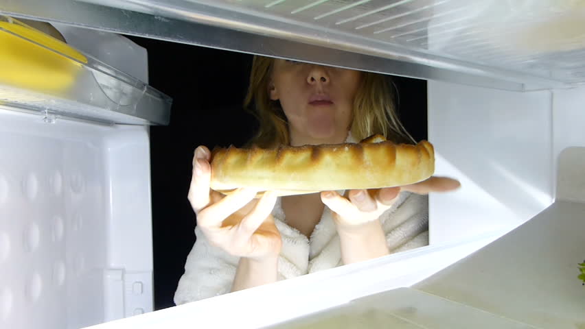 Woman opens the refrigerator at night. bulimia, sandwich, pastry