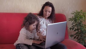 A girl with a child playing on a laptop