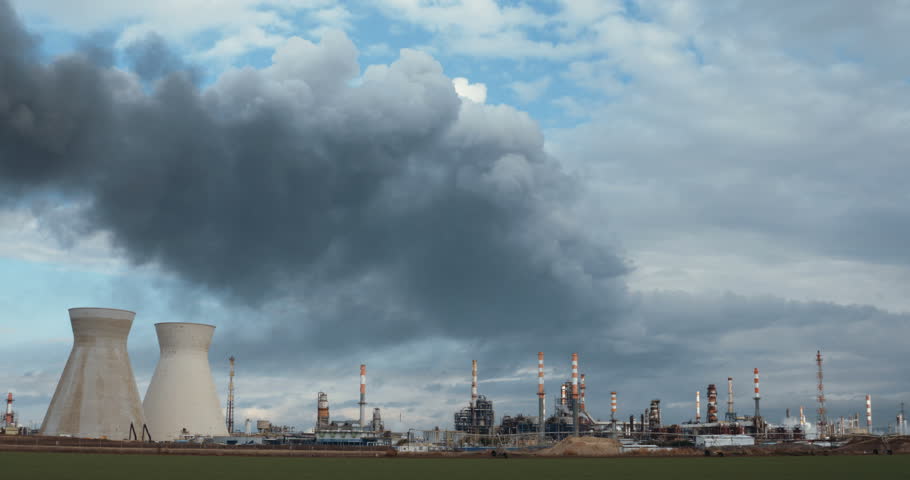 Big oil refinery with smoke rising from chimneys