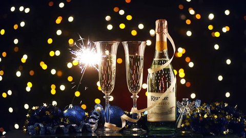 Christmas and New Year. Festive decorations, champagne and pair of flutes on the background lights. Slow shooting.