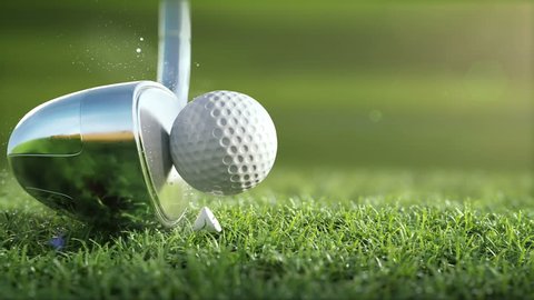 Golf club hits a golf ball in a super slow motion, in sunny morning. visible deformation of the ball, drops of dew and grass particles after impact raised in the air. Ultra-realistic 3D animation