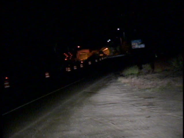A surreal new of passing through a road tunnel at night past construction barriers
