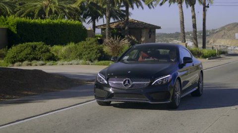 Black Mercedes C-class Coupe driving on the Malibu road