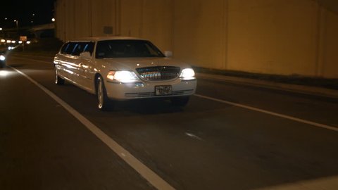 limousine driving through urban city night limo