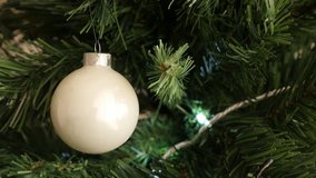 White Christmas tree reflective bauble with blinking dot lights on 4K 2160p 30fps UltraHD footage - Shiny glass ornament for New Year night decorations close-up 3840X2160 UHD video