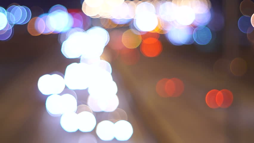 Unfocused highway traffic at night.