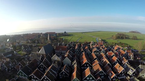 Aerial of Marken flying backwards away from typical Dutch village it forms a peninsula in Markermeer and was formerly an island in Zuiderzee characteristic wooden houses are a tourist attraction 4k