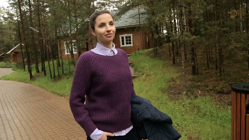 girl the brunette one with the purple sweater and shirt walking on the track is paved in the forest among trees in autumn day