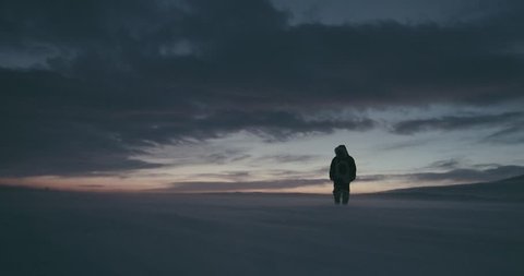 Young traveller dressed in traditional reindeer skin coat goes through a blizzard at beautiful sunset. Polar expedition 2016. Red Epic 4k resolution. HD