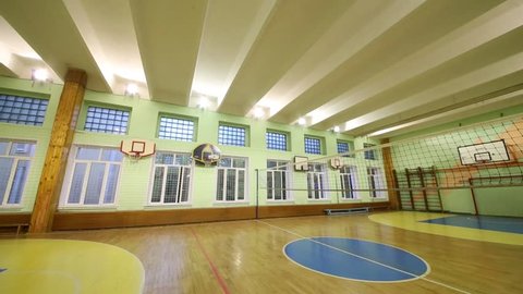 MOSCOW, RUSSIA - JUNE 28, 2016: The light turns off in a big empty sports hall with a volleyball net in the school 